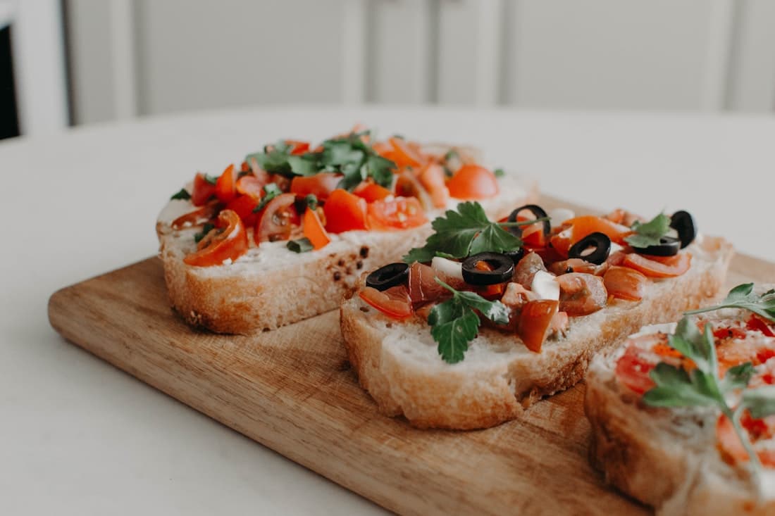 Ahşap tahta üzerinde kızarmış ekşi mayalı ekmekle bruschetta dilimleri